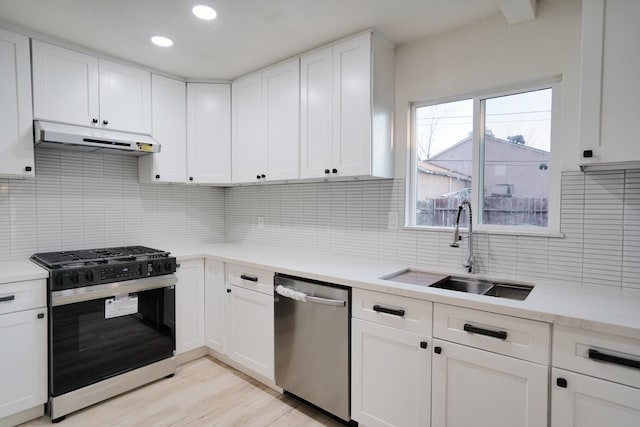 1530 E Home Ave, Fresno, CA 93728 - kitchen featuring appliances with stainless steel finishes, under cabinet range hood, light countertops, backsplash, and white cabinetry