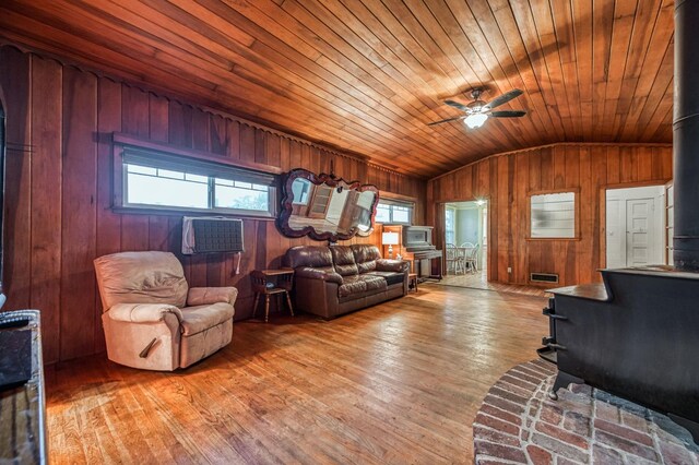 3303 E Mono Ave, Fresno, CA 93702 - living room with a wood stove, lofted ceiling, ceiling fan, healthy amount of natural light, and wood walls