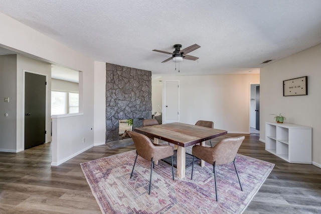 4245 N Manila Ave, Fresno, CA 93727 - dining room with a ceiling fan, a textured ceiling, wood finished floors, and a stone fireplace