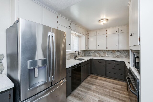 4245 N Manila Ave, Fresno, CA 93727 - kitchen featuring stainless steel appliances, light wood-style floors, light countertops, white cabinets, and tasteful backsplash