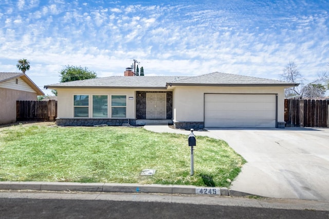 4245 N Manila Ave, Fresno, CA 93727 - ranch-style home with a garage, driveway, a chimney, stucco siding, and stone siding