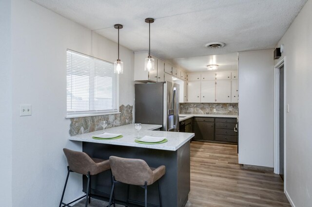 4245 N Manila Ave, Fresno, CA 93727 - kitchen featuring stainless steel fridge, a peninsula, decorative backsplash, wood finished floors, and light countertops