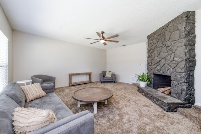 4245 N Manila Ave, Fresno, CA 93727 - living room with a ceiling fan, carpet floors, and a stone fireplace