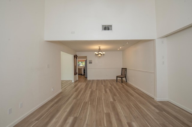 1535 S Homsy Ave, Fresno, CA 93727 - unfurnished room featuring a chandelier, light wood-type flooring, and a high ceiling