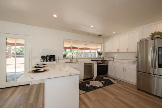 1535 S Homsy Ave, Fresno, CA 93727 - kitchen with stainless steel appliances, a peninsula, white cabinets, plenty of natural light, and recessed lighting