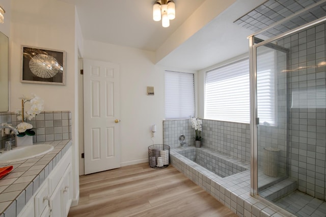 1535 S Homsy Ave, Fresno, CA 93727 - full bathroom with vanity, a bath, wood finished floors, tiled shower, and decorative backsplash