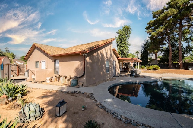1535 S Homsy Ave, Fresno, CA 93727 - rear view of property with stucco siding, a tiled roof, a patio area, and a gate