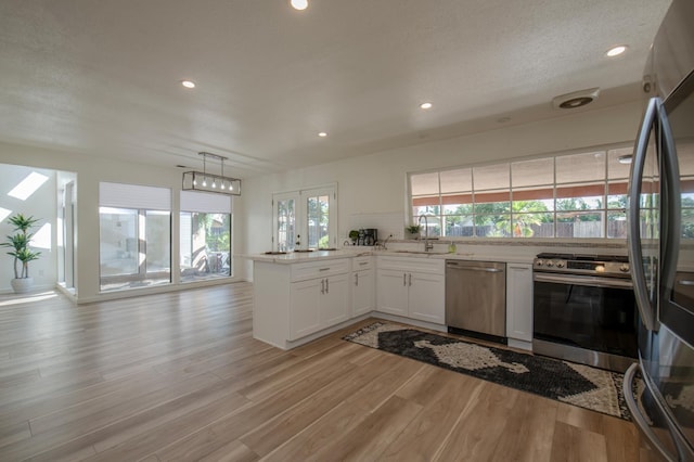 1535 S Homsy Ave, Fresno, CA 93727 - kitchen with appliances with stainless steel finishes, a peninsula, light wood-style flooring, white cabinets, and recessed lighting