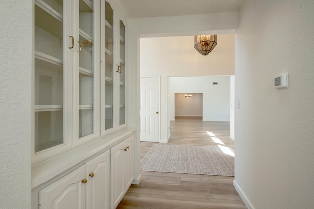 1535 S Homsy Ave, Fresno, CA 93727 - hall featuring light wood-style floors, a chandelier, and a textured wall