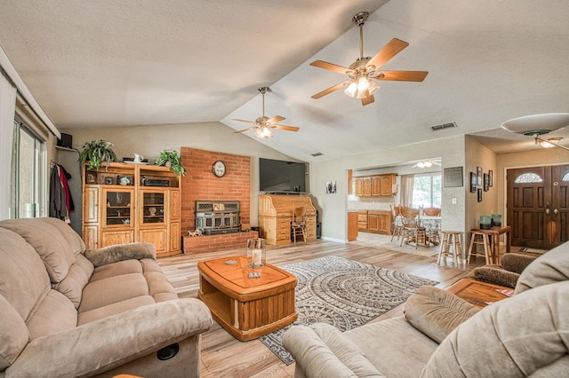 5400 Amber Ave, Clovis, CA 93619 - living area featuring light wood finished floors, lofted ceiling, ceiling fan, a textured ceiling, and a brick fireplace