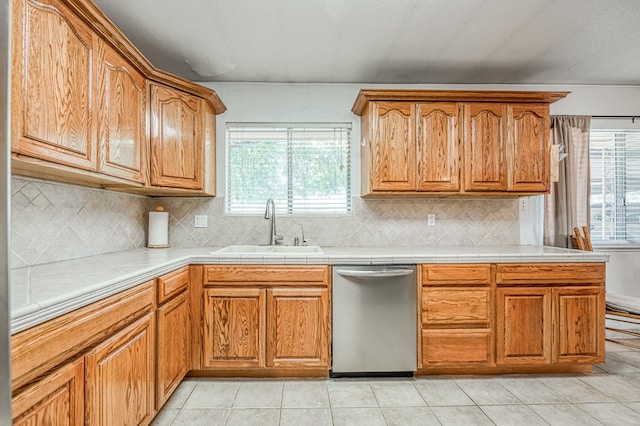 5400 Amber Ave, Clovis, CA 93619 - kitchen featuring stainless steel dishwasher, decorative backsplash, tile countertops, and brown cabinetry