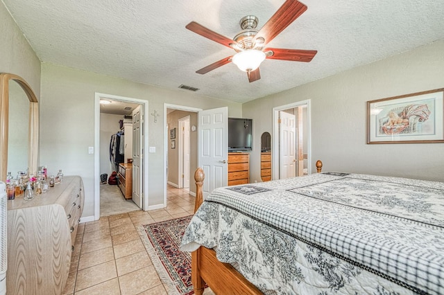 5400 Amber Ave, Clovis, CA 93619 - bedroom featuring arched walkways, a textured ceiling, a spacious closet, light tile patterned floors, and a closet