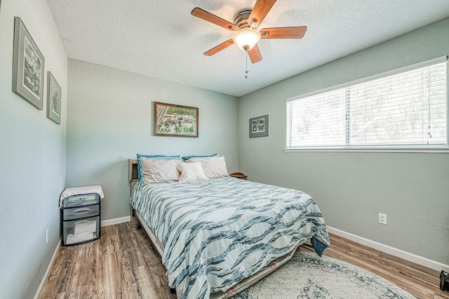 5400 Amber Ave, Clovis, CA 93619 - bedroom featuring wood finished floors, a textured ceiling, and a ceiling fan