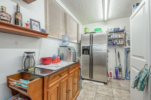 5400 Amber Ave, Clovis, CA 93619 - kitchen with stainless steel fridge with ice dispenser, a textured ceiling, brown cabinets, dark countertops, and light tile patterned flooring