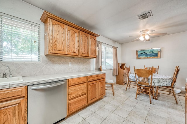 5400 Amber Ave, Clovis, CA 93619 - kitchen featuring dishwasher, tile countertops, backsplash, a ceiling fan, and light tile patterned floors