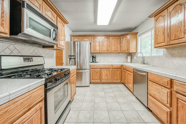 5400 Amber Ave, Clovis, CA 93619 - kitchen featuring stainless steel appliances, tile countertops, and decorative backsplash
