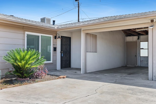 2044 Mayfair Dr W, Fresno, CA 93703 - view of exterior entry featuring roof with shingles, concrete driveway, and stucco siding