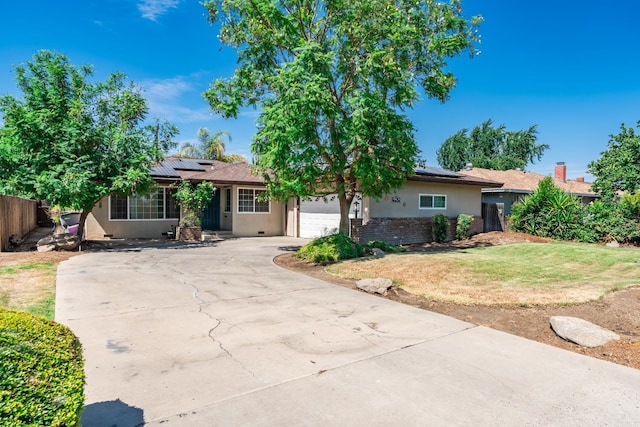 4625 E Princeton Ave, Fresno, CA 93703 - view of front of house featuring solar panels, stucco siding, an attached garage, and driveway