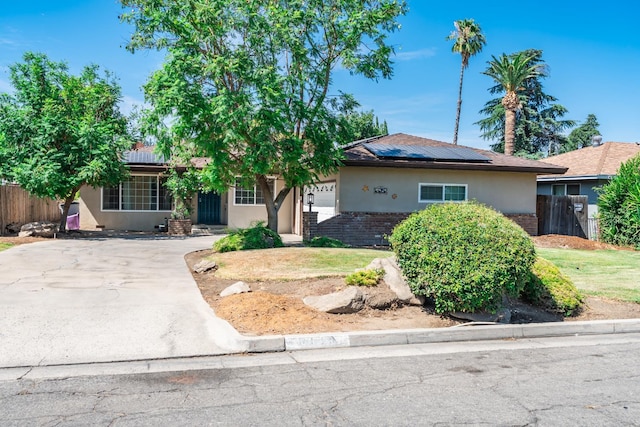 4625 E Princeton Ave, Fresno, CA 93703 - view of front of home featuring stucco siding, solar panels, and concrete driveway