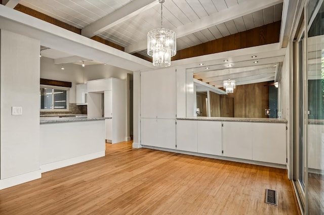 1095 W San Ramon Ave, Fresno, CA 93711 - unfurnished living room with a chandelier, beam ceiling, and light wood-style flooring
