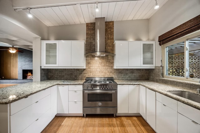 1095 W San Ramon Ave, Fresno, CA 93711 - kitchen with rail lighting, high end stainless steel range oven, wall chimney exhaust hood, ceiling fan, and tasteful backsplash