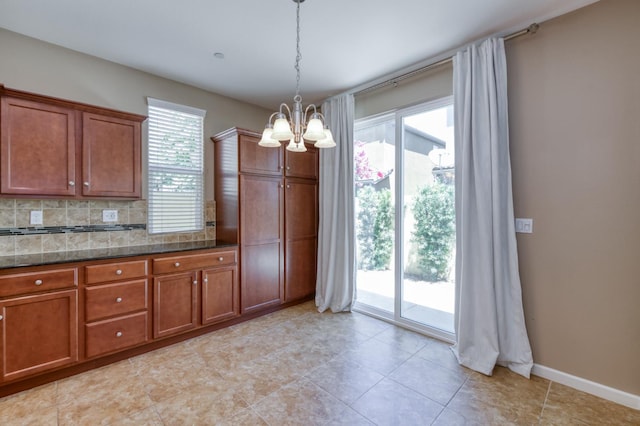 3563 Magnificent Way, Clovis, CA 93619 - kitchen with a chandelier, brown cabinetry, decorative light fixtures, dark stone counters, and backsplash