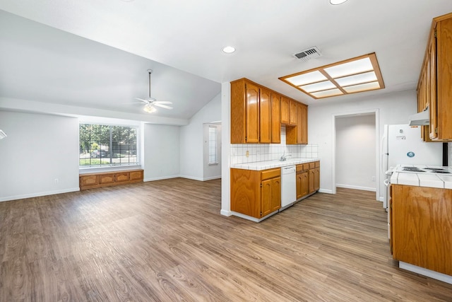 5137 W Stuart Ave, Fresno, CA 93722 - kitchen with white dishwasher, under cabinet range hood, tile countertops, ceiling fan, and light wood-style flooring