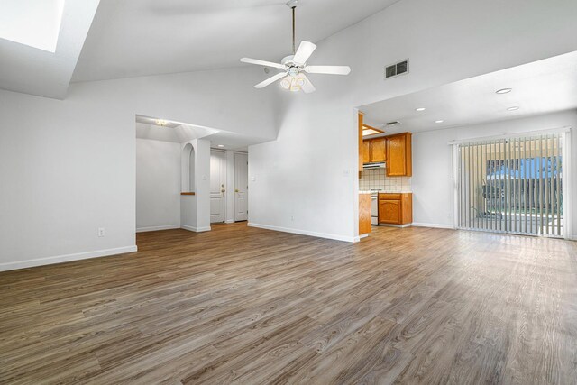 5137 W Stuart Ave, Fresno, CA 93722 - unfurnished living room with wood finished floors, high vaulted ceiling, ceiling fan, recessed lighting, and a skylight