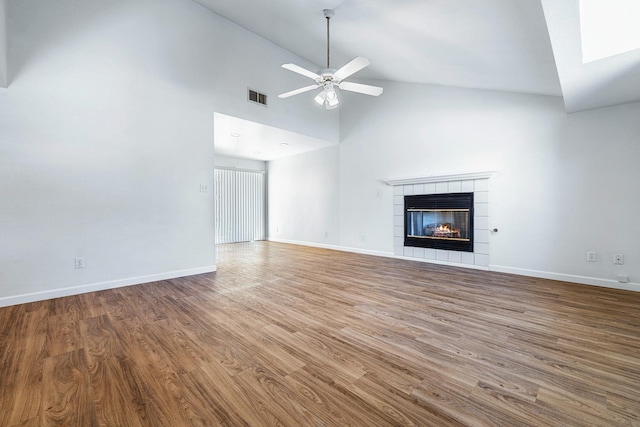 5137 W Stuart Ave, Fresno, CA 93722 - unfurnished living room with wood finished floors, a fireplace, ceiling fan, and high vaulted ceiling