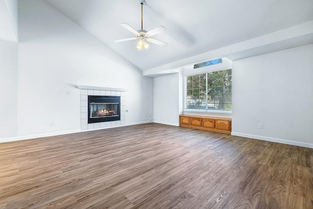 5137 W Stuart Ave, Fresno, CA 93722 - unfurnished living room featuring wood finished floors, high vaulted ceiling, a tiled fireplace, and ceiling fan