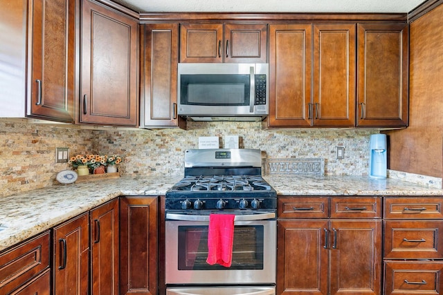 317 W Sierra Ave Unit 107, Fresno, CA 93704 - kitchen featuring appliances with stainless steel finishes, backsplash, and light stone countertops