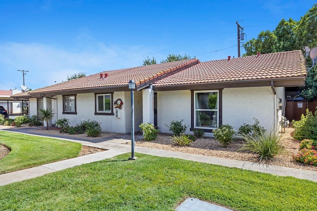317 W Sierra Ave Unit 107, Fresno, CA 93704 - view of front facade with stucco siding, a front lawn, and a tile roof