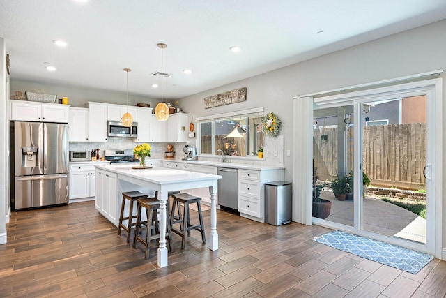 4053 Rialto Ave, Clovis, CA 93619 - kitchen featuring stainless steel appliances, light countertops, white cabinets, dark wood-type flooring, and tasteful backsplash