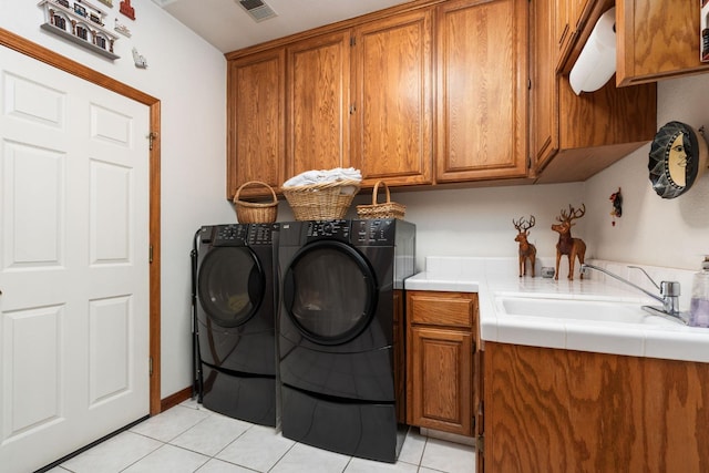 7207 E Bremer Ave, Fresno, CA 93737 - washroom with cabinet space, washing machine and dryer, and light tile patterned flooring