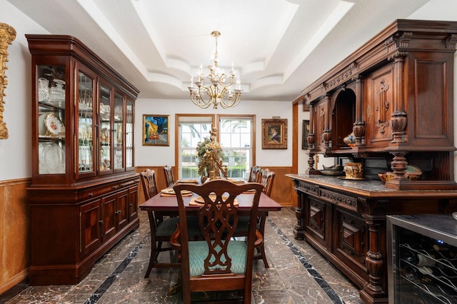 7207 E Bremer Ave, Fresno, CA 93737 - dining room with inlaid floor details, a chandelier, wainscoting, dark marble finish floors, and a raised ceiling