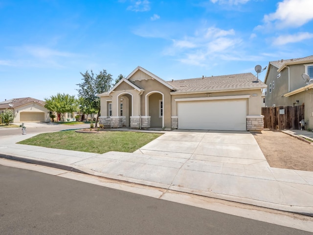2303 S Bush Ave, Fresno, CA 93727 - view of front of home with stucco siding, a garage, concrete driveway, and stone siding