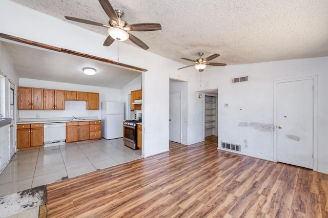 22 Beverly Dr, Clovis, CA 93612 - kitchen with white appliances, vaulted ceiling, ceiling fan, a textured ceiling, and light countertops