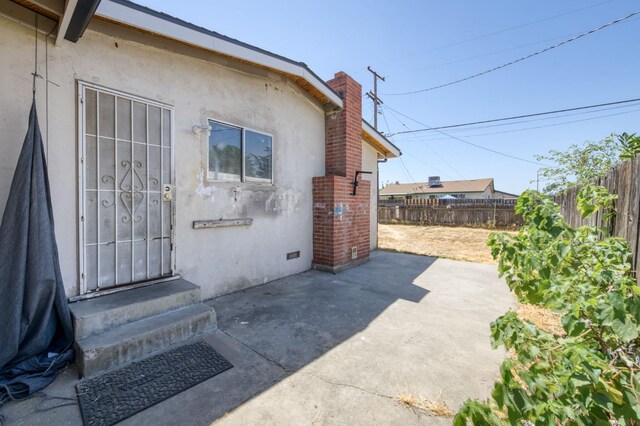 22 Beverly Dr, Clovis, CA 93612 - view of exterior entry featuring stucco siding, a patio, and a chimney
