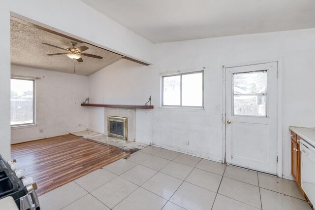 22 Beverly Dr, Clovis, CA 93612 - unfurnished living room with plenty of natural light, lofted ceiling, a tiled fireplace, and light tile patterned floors