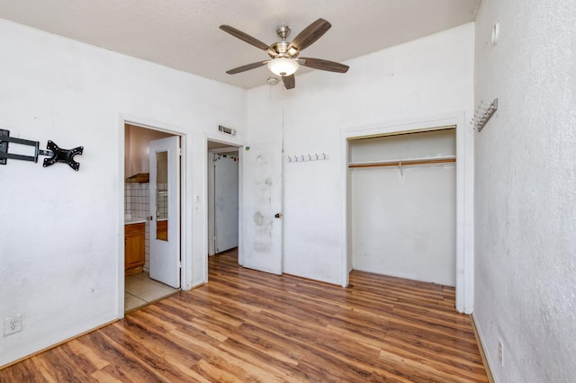22 Beverly Dr, Clovis, CA 93612 - unfurnished bedroom featuring wood finished floors, a closet, ensuite bathroom, and a ceiling fan