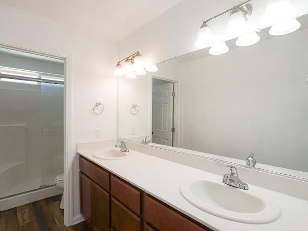435 E San Pedro St, Merced, CA 95341 - bathroom featuring double vanity, a stall shower, and wood finished floors