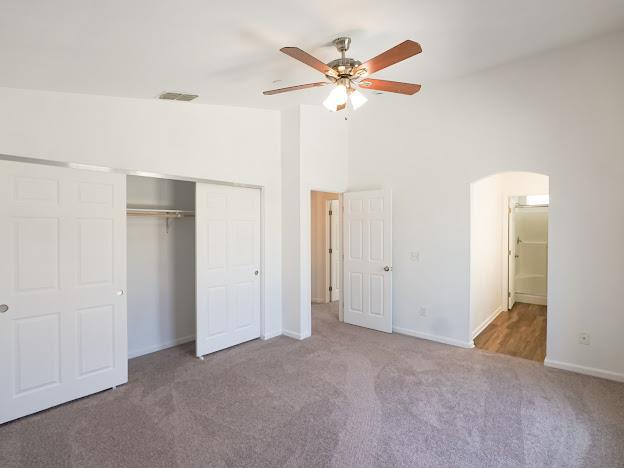 435 E San Pedro St, Merced, CA 95341 - unfurnished bedroom featuring carpet, a closet, arched walkways, ceiling fan, and high vaulted ceiling