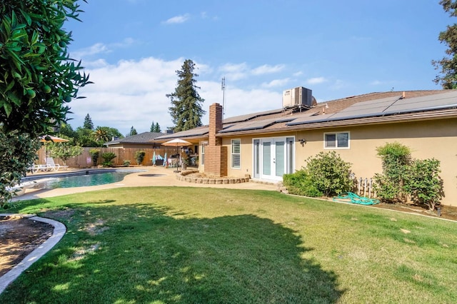 6658 N Thorne Ave, Fresno, CA 93711 - back of property with french doors, roof mounted solar panels, a fenced backyard, stucco siding, and a patio area