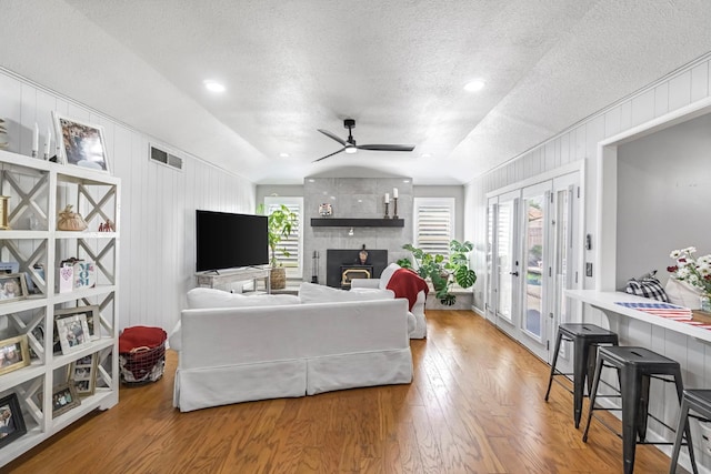 6658 N Thorne Ave, Fresno, CA 93711 - living area featuring vaulted ceiling, a textured ceiling, a fireplace, a ceiling fan, and wood finished floors