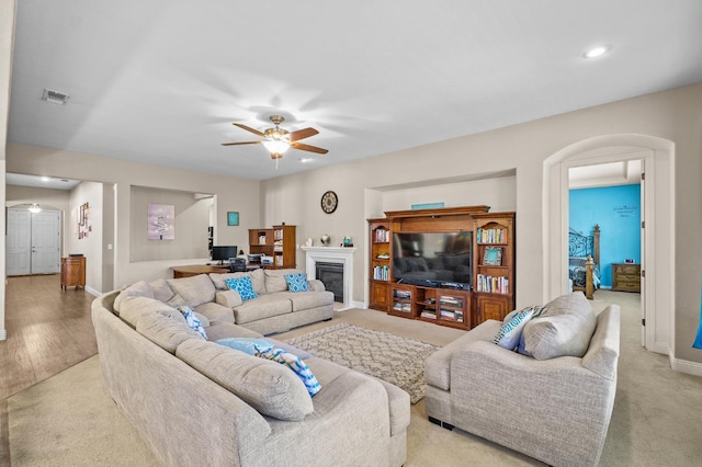 2403 W Robin Ave, Visalia, CA 93291 - living room with arched walkways, a ceiling fan, recessed lighting, and a glass covered fireplace