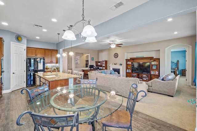 2403 W Robin Ave, Visalia, CA 93291 - dining room with arched walkways, ceiling fan, recessed lighting, wood finished floors, and a chandelier