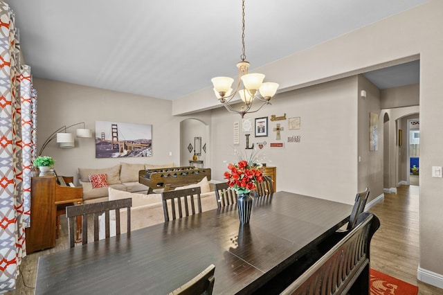 2403 W Robin Ave, Visalia, CA 93291 - dining space with arched walkways, a chandelier, and wood finished floors