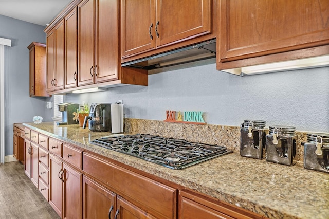 2403 W Robin Ave, Visalia, CA 93291 - kitchen with under cabinet range hood, black gas cooktop, light wood-style floors, and brown cabinetry