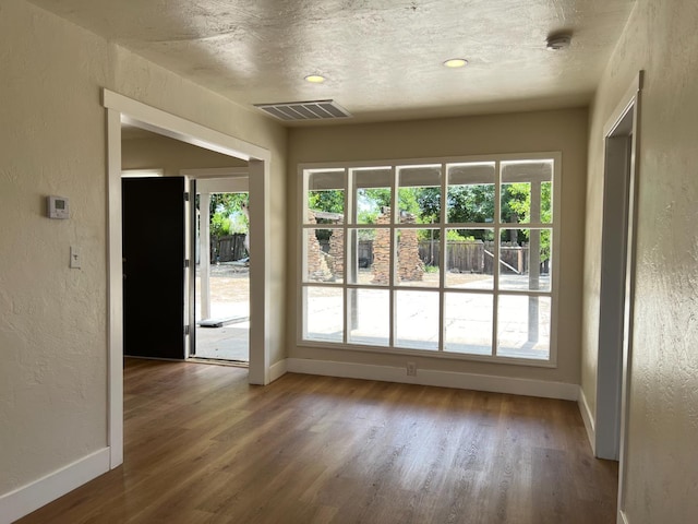 7013 N Maroa Ave, Pinedale, CA 93650 - unfurnished room featuring a textured wall, wood finished floors, healthy amount of natural light, a textured ceiling, and a smoke detector