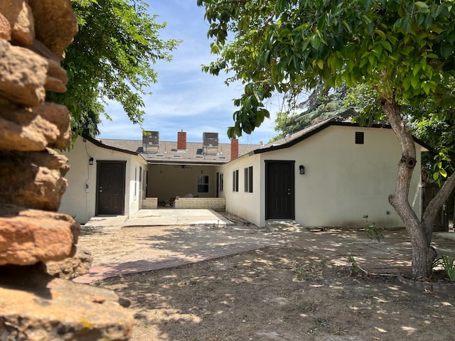 7013 N Maroa Ave, Pinedale, CA 93650 - back of property featuring stucco siding, a patio, and a chimney